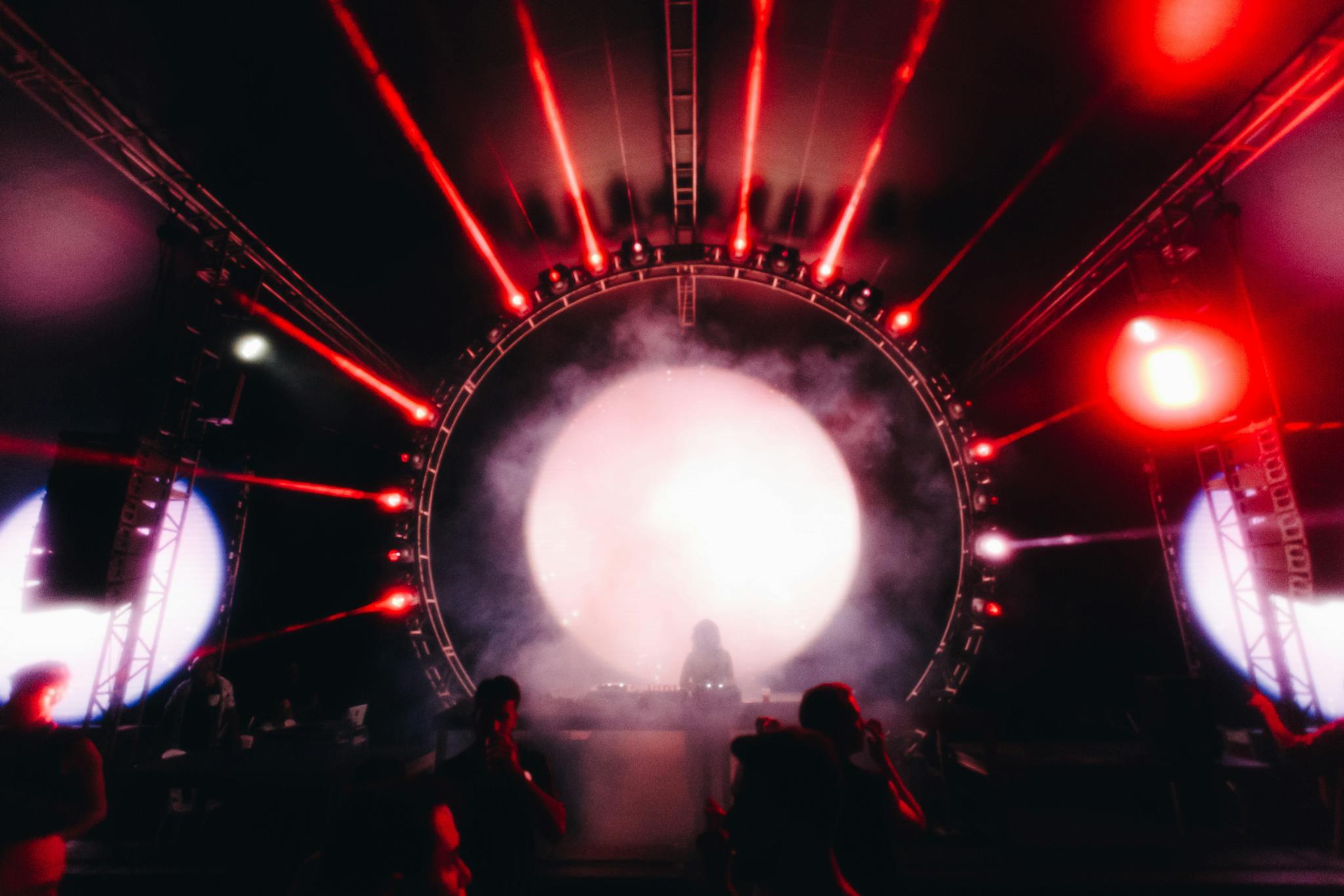 Vibrant DJ performance with striking red lasers and crowd in Brazil nightclub.